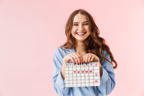 生理日カレンダーを持ってほほ笑む女性
